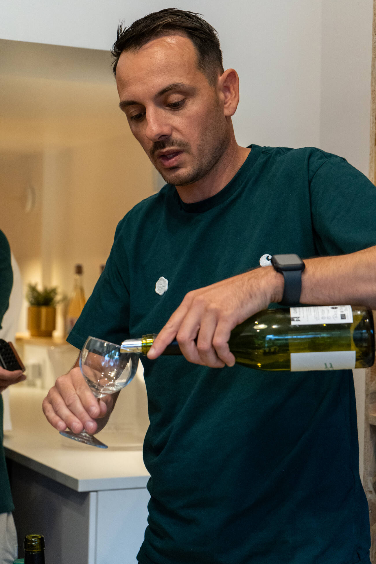 Thibaud sert un verre au comptoir de la cave